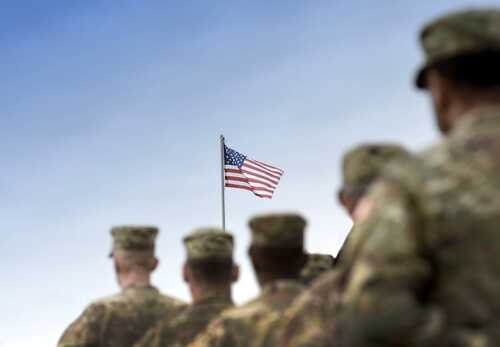 shutterstock_2380883205 (2).jpg Soldiers standing in formation with an American flag in the background
