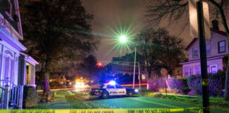 Police car at night with caution tape nearby