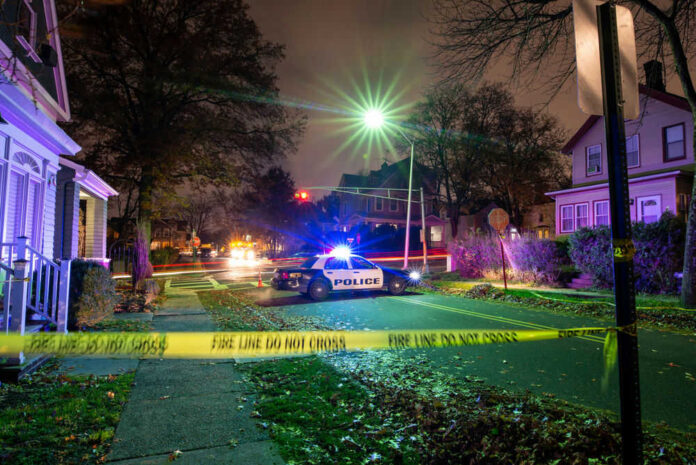 Police car at night with caution tape nearby