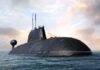 A submarine partially submerged in the ocean under a cloudy sky