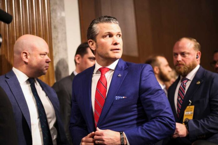 Man in a blue suit adjusting his jacket at a political event surrounded by security personnel