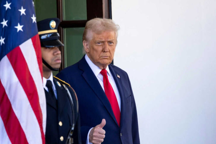 Man giving thumbs up beside American flag and guard