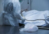 Person in protective gear handling body bag