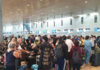 Crowded airport checkin area with many passengers waiting