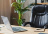 Office desk with laptop and black leather chair