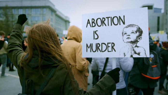 Person holding protest sign about abortion at rally