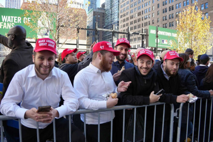 2536603823 Group wearing red hats behind a barricade outside