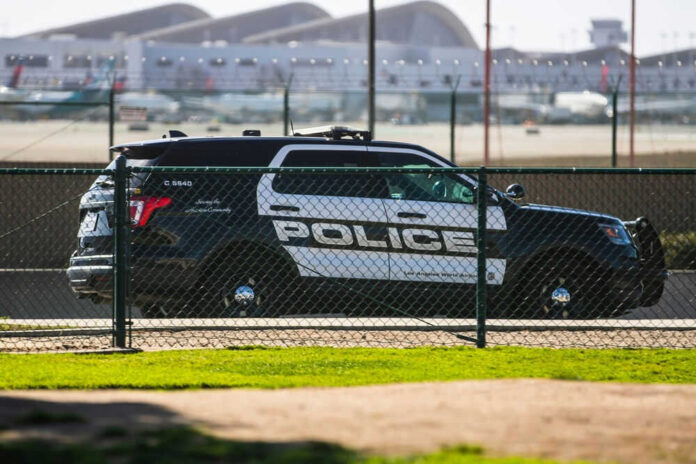 Police car parked near airport runway fence