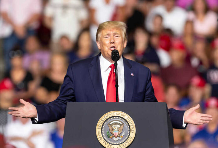 Man speaking at podium with seal in crowded venue