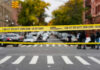 Yellow crime scene tape across urban street intersection