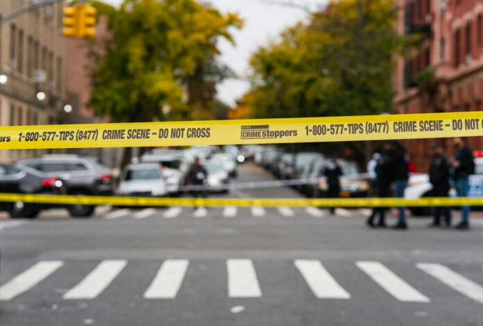 Yellow crime scene tape across urban street intersection