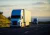 Two semitrucks driving on a highway