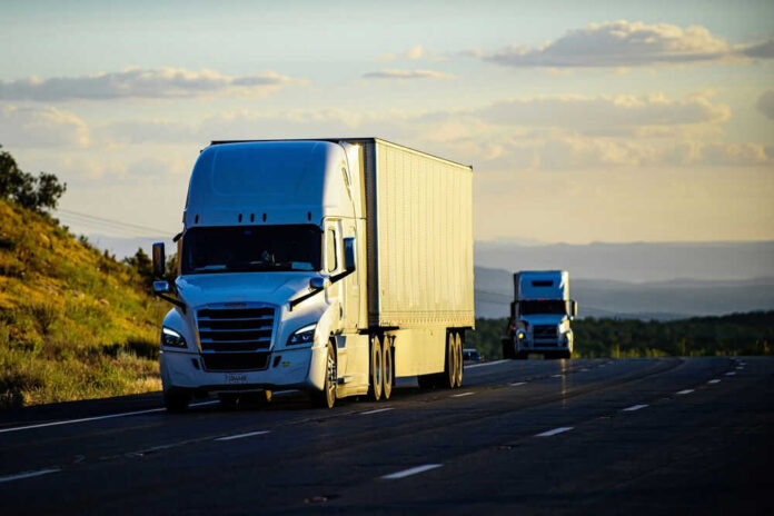 Two semitrucks driving on a highway
