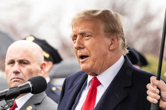 Two men speaking at an outdoor event in suits