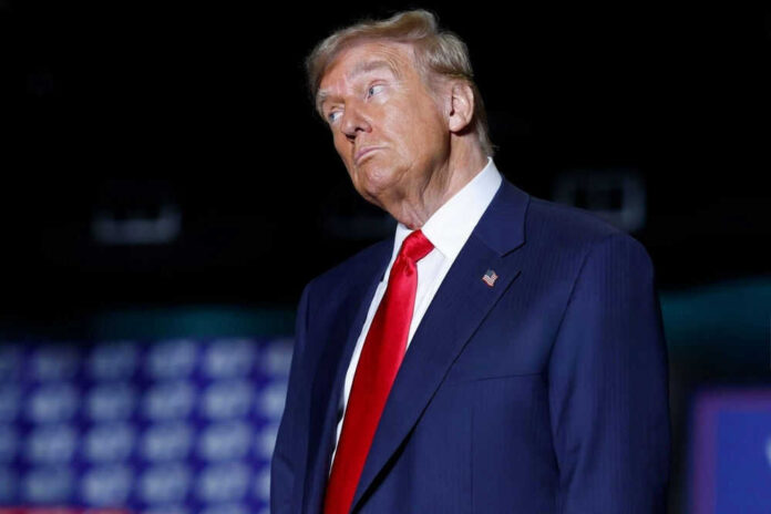 Man in suit and red tie looking sideways