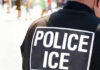 Police officers back with ICE label visible