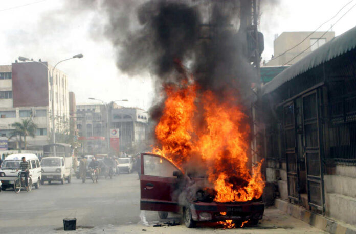 Car engulfed in flames on busy urban street