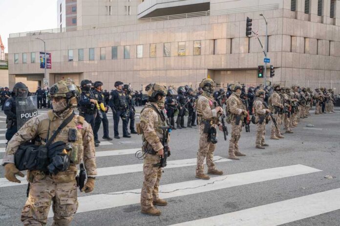 Line of law enforcement officers in tactical gear standing on a city street