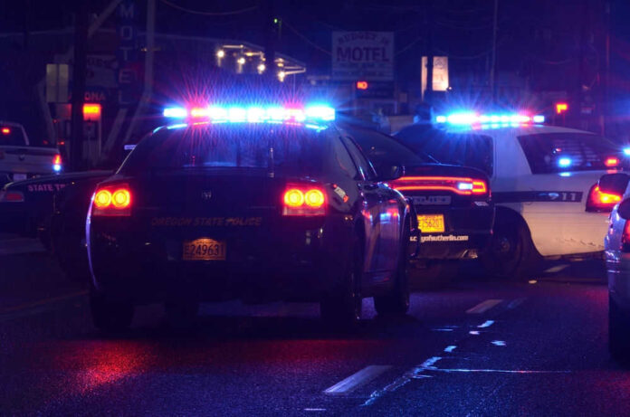 Police vehicles with flashing lights on nighttime street