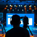Camera crew filming a brightly lit stage