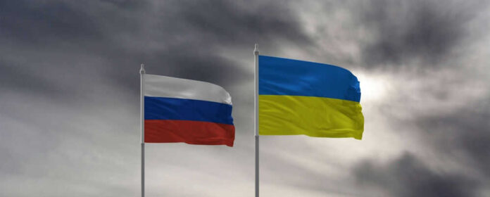 Russian and Ukrainian flags against cloudy sky