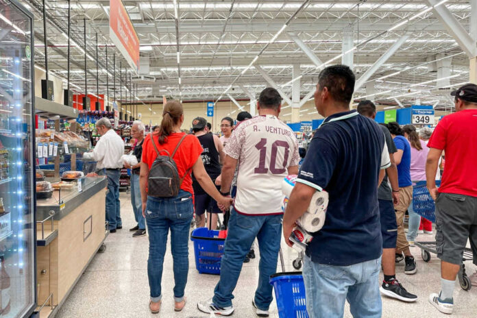 People shopping in a busy supermarket aisle