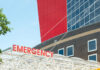 Emergency sign outside modern building with windows