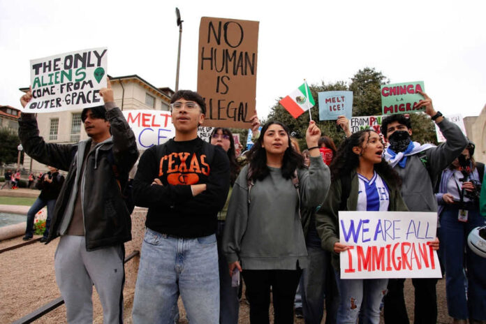 2588942051 Group of people holding various protest signs outdoors