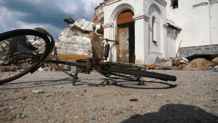 Bicycle on ground near damaged building steps skyward