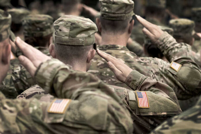 Soldiers saluting in uniform with American flag patches