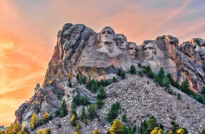 Mount Rushmore with trees and colorful sky background