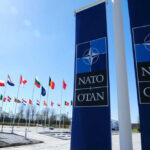 NATO flags and banners under clear blue sky