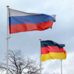 Russian and German flags waving on poles outside