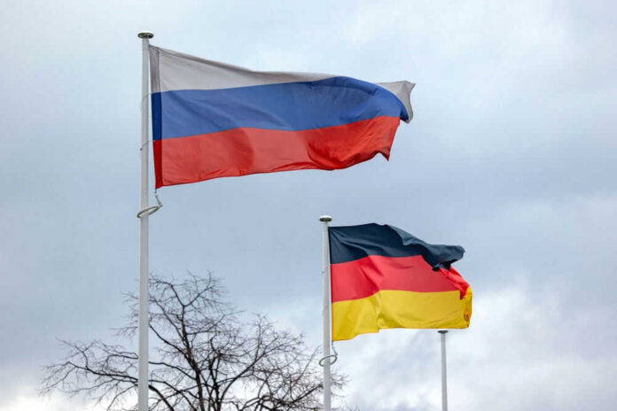 Russian and German flags waving on poles outside