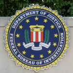 FBI seal on stone wall with foliage background