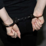 Person in handcuffs wearing black clothing