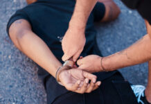 Chicago Loses 200 Criminals on Ankle Monitors Person being handcuffed on the ground outdoors
