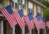 Town Targets Flags Over Birds American flags displayed outside yellow building