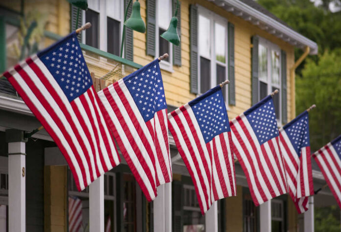79239076 American flags displayed outside yellow building